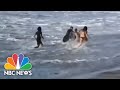 Video Captures Pro Surfer Rescuing Woman Caught In Rough Waves | NBC Nightly News
